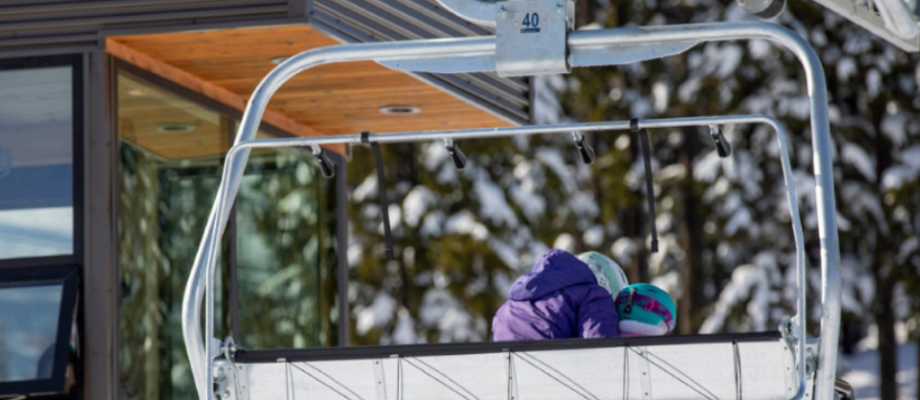 A ski lift with two people in winter gear