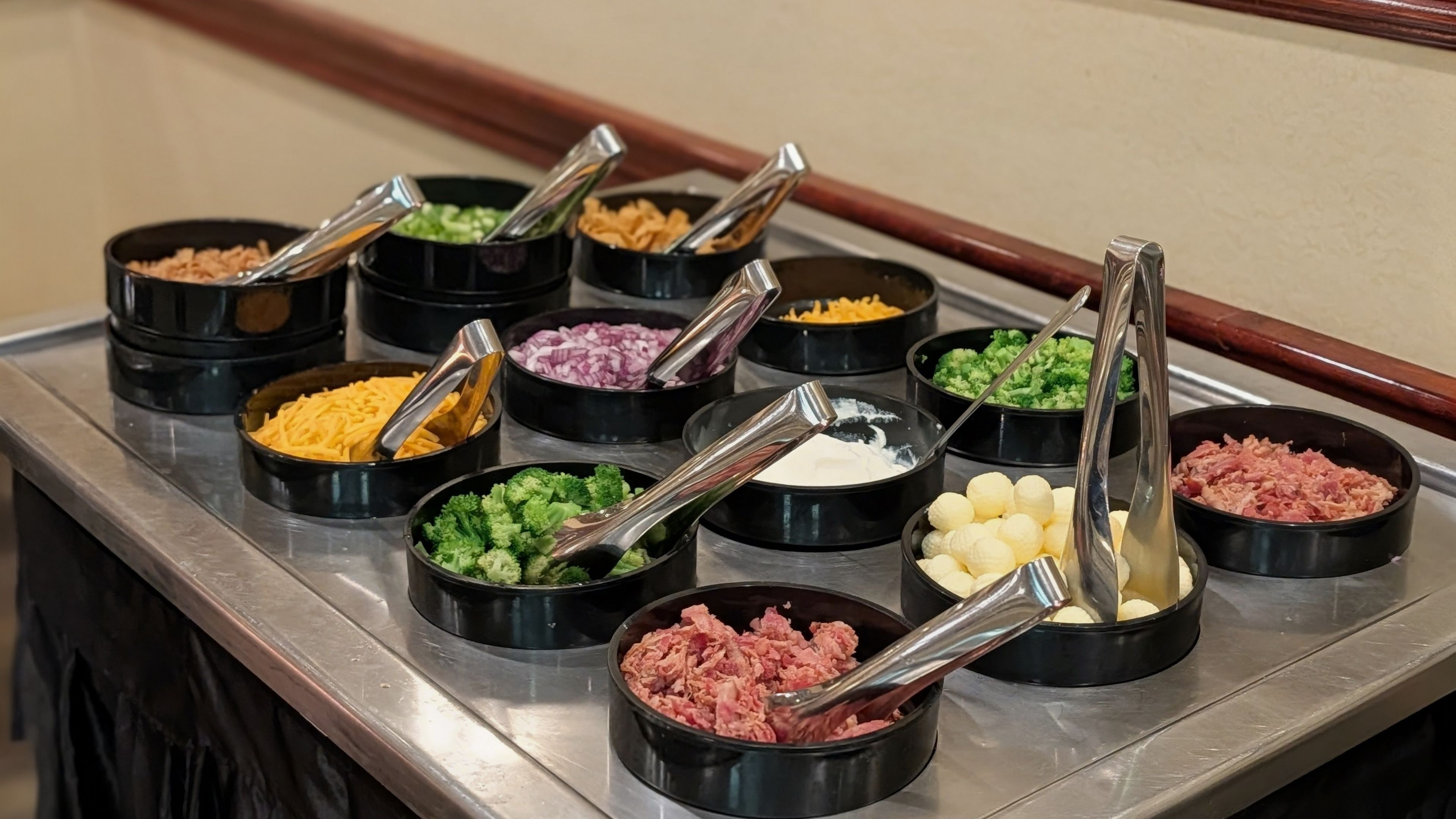 A buffet with various toppings in small black bowls